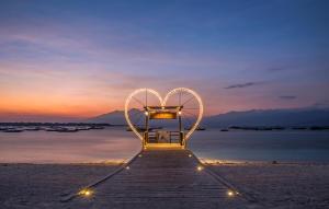 吉利特拉旺安欧巴克别墅饭店的日落时分海滩上一张心亮的长椅