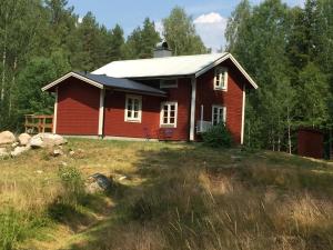 Östra LöaHyttsnåret的田野上山丘上的红房子