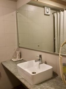 普塔帕蒂Sai Towers的浴室设有白色水槽和镜子