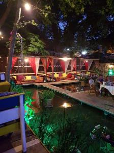 阿德拉桑阿尔坎达河花园酒店的夜间游泳池,人们坐在帐篷周围