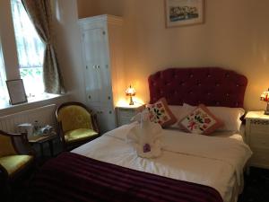 彭赞斯埃斯托利尔酒店的卧室配有白色床和红色床头板