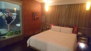 新竹向日葵汽车旅馆 的一间卧室设有一张床、一个窗户和一间浴室