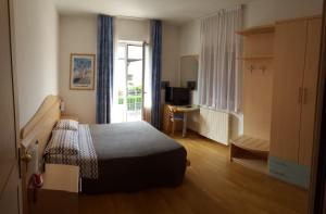 阿维奥小花酒店的一间卧室配有一张床、一张书桌和一个窗户。