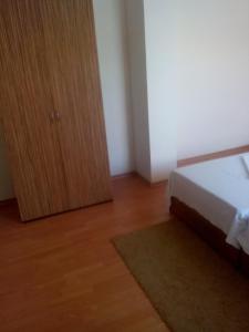 阿赫洛伊Guest House Hristovi的一间卧室配有一张床和一个木制橱柜