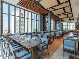 三亚三亚大东海酒店的餐厅设有木桌、椅子和窗户。