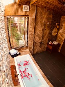 富国珊瑚湾度假酒店的浴室配有带红色鲜花的浴缸。