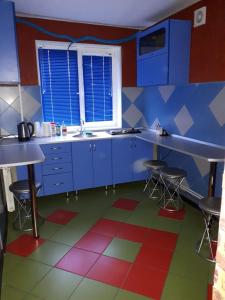 KanskАпартаменты двухкомнатные的厨房配有蓝色橱柜和色彩缤纷的地板