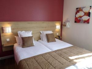 弗兰奎维尔-圣皮尔鲁昂庭院酒店的卧室配有一张带白色床单和枕头的大床。