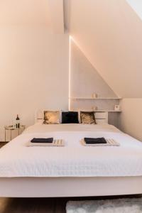 弗罗茨瓦夫GoldenEye Apartment Center的卧室配有一张带两个枕头的大白色床
