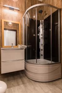 弗罗茨瓦夫GoldenEye Apartment Center的带淋浴和盥洗盆的浴室