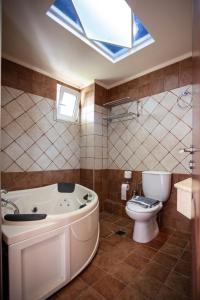 普拉基亚斯Porto Plakias & Spa的带浴缸、卫生间和天窗的浴室