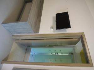 庞贝Camping Zeus的一间带镜子的浴室和墙上的电视