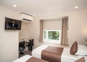 伦敦NOX Olympia的一间酒店客房,设有两张床和电视