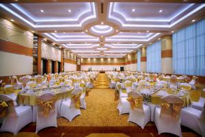 马格朗马格朗阿特里亚酒店的一个带白色桌椅的大型宴会厅