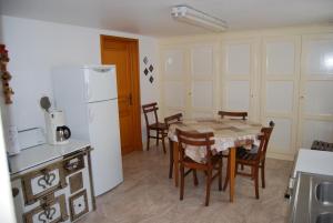 Gertwiller乐托凯艾特乐马斯喀特酒店的厨房配有桌椅和白色冰箱。