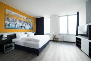 杜塞尔多夫杜塞尔多夫克拉特城市酒店的一间卧室配有一张床和一台平面电视