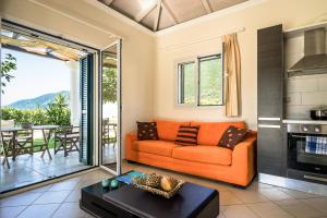 瓦西利基Aktes villas的客厅配有橙色沙发和桌子