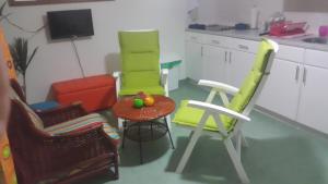 拉贡Alifra Apartment的厨房配有三把椅子和一张带水果的桌子
