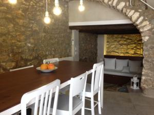 SalsadellaCal Matiner Casa Rural ***的一间带木桌和白色椅子的用餐室