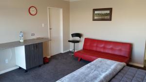 Hampden莫莱克博德尔汽车旅馆的一张红色沙发,位于带书桌的房间里