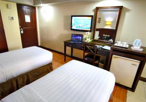 马尼拉费索酒店 - 马尼拉的酒店客房设有两张床、一张桌子和一台电视。
