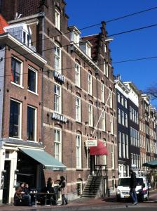 阿姆斯特丹OZO Hotels Armada Amsterdam的一座大型砖砌建筑,外面的人坐在