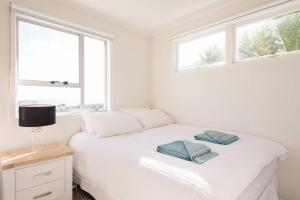 旺阿帕劳阿Luxury house with Clifftop Seaview的卧室配有白色的床和2条毛巾