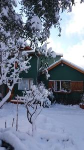 圣马丁德洛斯Colibrí House的前面有一棵雪覆盖的树的房子
