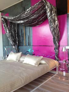 托里德尔贝纳科拜亚代皮尼酒店的粉红色墙壁的房间里一张床位