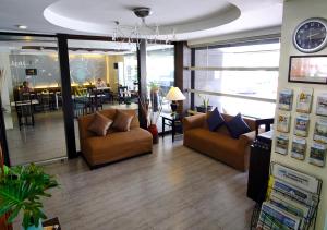 马尼拉海王星马卡提福赛尔酒店的客厅设有两张沙发和墙上的时钟
