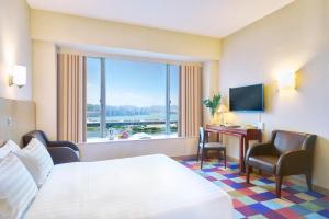 香港悦品海景酒店(观塘)的配有一张床、一张书桌和一扇窗户的酒店客房