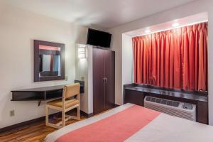 查塔努加Motel 6 Chattanooga Downtown的酒店客房配有一张床、一张书桌和一台电视。