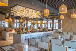 岘港海安海滩Spa酒店的一间带桌椅的餐厅和一间酒吧