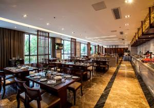 武夷山武夷山佰翔花园酒店的一间带木桌椅的餐厅和一间酒吧