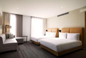 墨尔本Hyatt Place Melbourne Essendon Fields的酒店客房,设有两张床和一张沙发