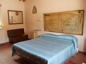 CrespinaAgriturismo L'isola的一间卧室配有蓝色的床和椅子