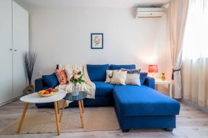 索非亚Urban Garden的客厅配有一张蓝色的沙发,配有一张桌子