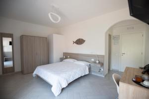 圣费利切-奇尔切奥La Conchiglia sul Mare的卧室配有白色的床、桌子和书桌