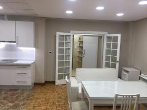 马拉加Apartments soho, Malaga center的厨房配有白色橱柜和白色桌子