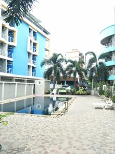 邦盛洛萨柏公寓酒店的棕榈树建筑前的游泳池