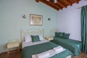 特劳洛斯斯亚索斯岛屿套房酒店的绿白色客房内的两张床