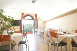 斯波莱托Ostello Villa Redenta的一间带桌椅的用餐室和窗户。