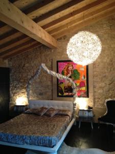 托里德尔贝纳科拜亚代皮尼酒店的一间卧室配有一张大床和一个吊灯。