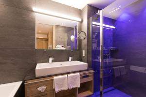 伊施格尔Alpenhotel Ischglerhof的一间带水槽和镜子的浴室