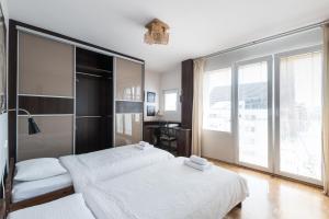 弗罗茨瓦夫Samba Apartment的一间卧室设有两张床和大窗户