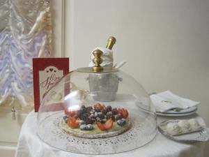 马里纳迪马萨马蒂尔德酒店的一块玻璃圆顶上的蛋糕,上面有水果盘