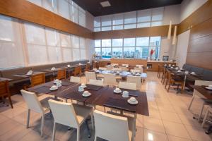 萨尔瓦多Iguatemi Business & Flat by Avectur的用餐室配有桌椅和大窗户