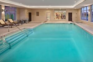 沃里克Hyatt Place Warwick/Providence Airport的酒店客房内的大型游泳池为蓝色海水。