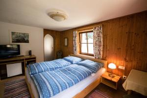 格施尼茨皮尔森霍夫农家乐的一间卧室配有一张带蓝色棉被的床和窗户。