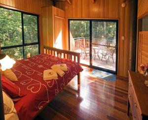 春溪斯普林布如克里瑞伯德瑞翠特酒店的一间卧室配有一张带红色棉被的床和甲板